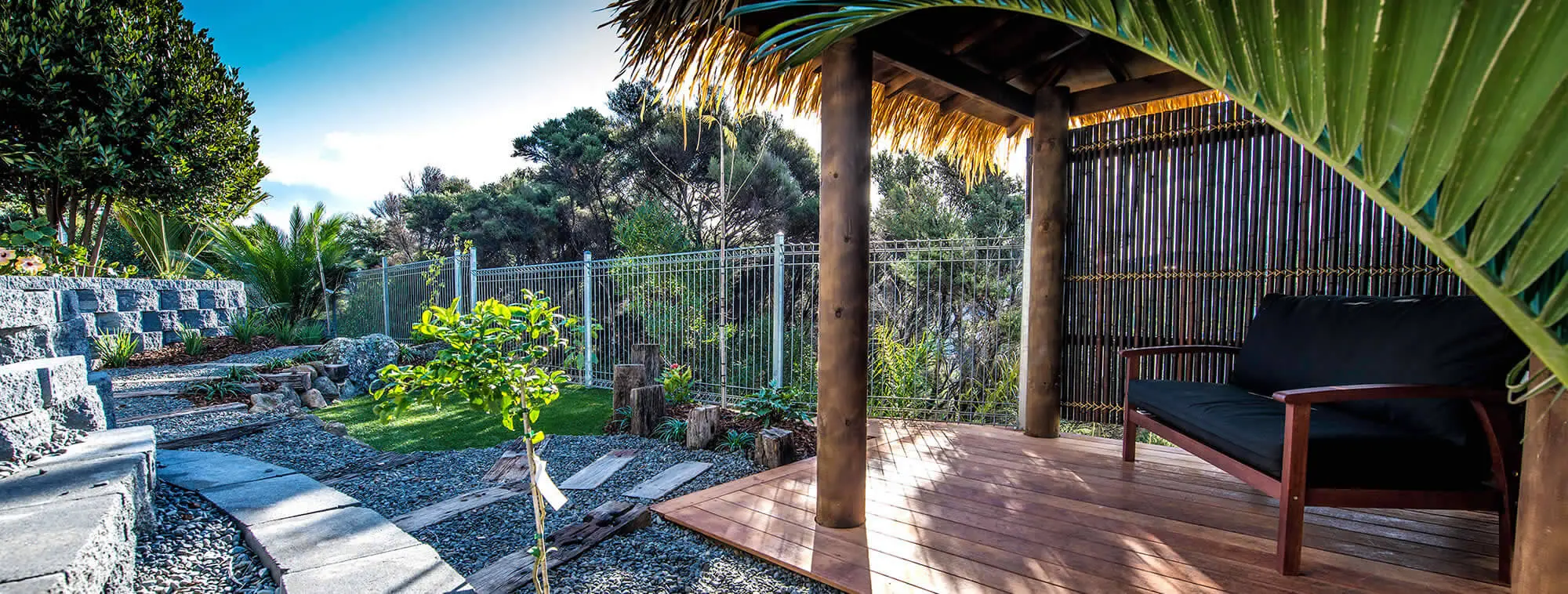 Custom landscape design showing a pergola and deck with retaining walls and fencing in Whangarei